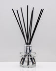 Creamy coconut, zesty lime, sweet orange and crisp apple Luxury long lasting Coconut Lime reed diffuser with natural black sticks in a 100ml clear glass bottle with silver top