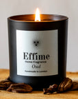 Effime Home Oud scented soy candle in a matt black glass jar surrounded with oud woods
