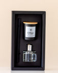 Candle and perfume set in a black box on a beige background