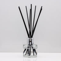 Experience the warm rich, smoky essence of rare Oud wood Luxury long lasting Oud reed diffuser with natural black sticks in a 100ml clear glass bottle with silver top