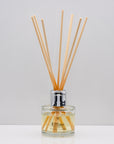 Wrap yourself in the comforting warmth of burnt wood and vanilla Luxury long lasting Woody Vanilla reed diffuser with natural wooden sticks in a 100ml clear glass bottle with silver top