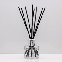 Snuggle up on a cold winter's night and indulge your senses with opulent aromas of rich Luxury long lasting Black Pomegranate reed diffuser with natural black sticks in a 100ml clear glass bottle with silver top