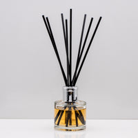Fill your home with the magical aromas of all things cosy. Fresh crisp orange combined with traditional spicy nuances of cinnamon Luxury long lasting Cinnamon Orange reed diffuser with natural black sticks in a 100ml clear glass bottle with silver top.