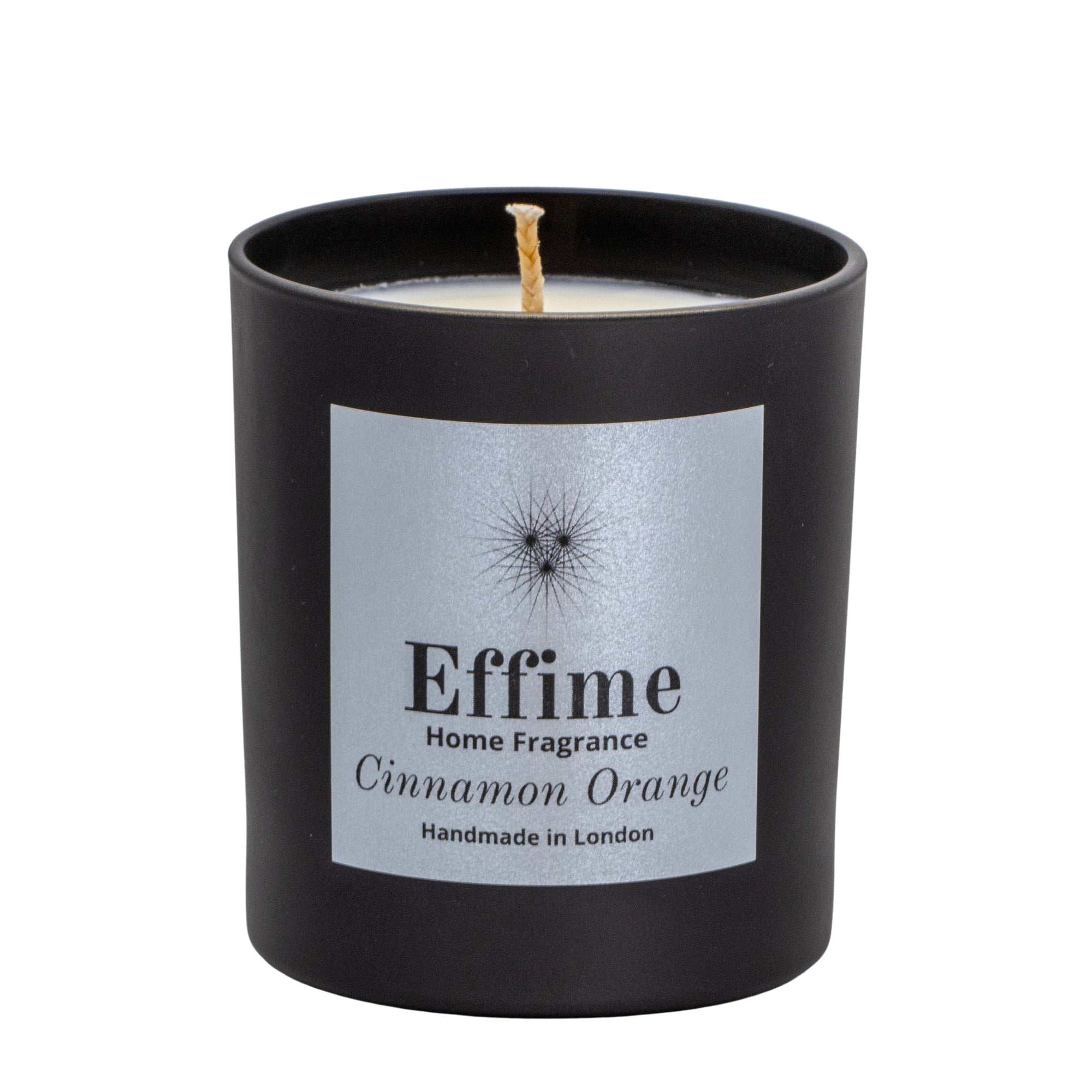 "Scented candle: Black glass jar with silver label reading 'Effime Home Fragrance Cinnamon Orange'. 
Luxury  Spicy, Woody, Fruity home fragrance"