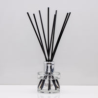 Creamy coconut, zesty lime, sweet orange and crisp apple Luxury long lasting Coconut Lime reed diffuser with natural black sticks in a 100ml clear glass bottle with silver top