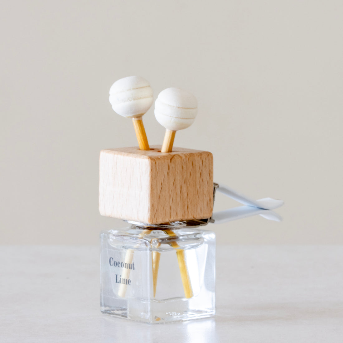 Creamy coconut, zesty lime, sweet orange and crisp apple Luxury long lasting Coconut Lime Car diffuser with natural wooden sticks in a clear glass bottle with wooden top