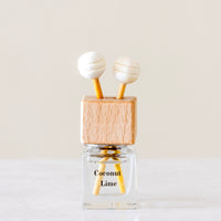 Creamy coconut, zesty lime, sweet orange and crisp apple Luxury long lasting Coconut Lime Car diffuser with natural wooden sticks in a clear glass bottle with wooden top
