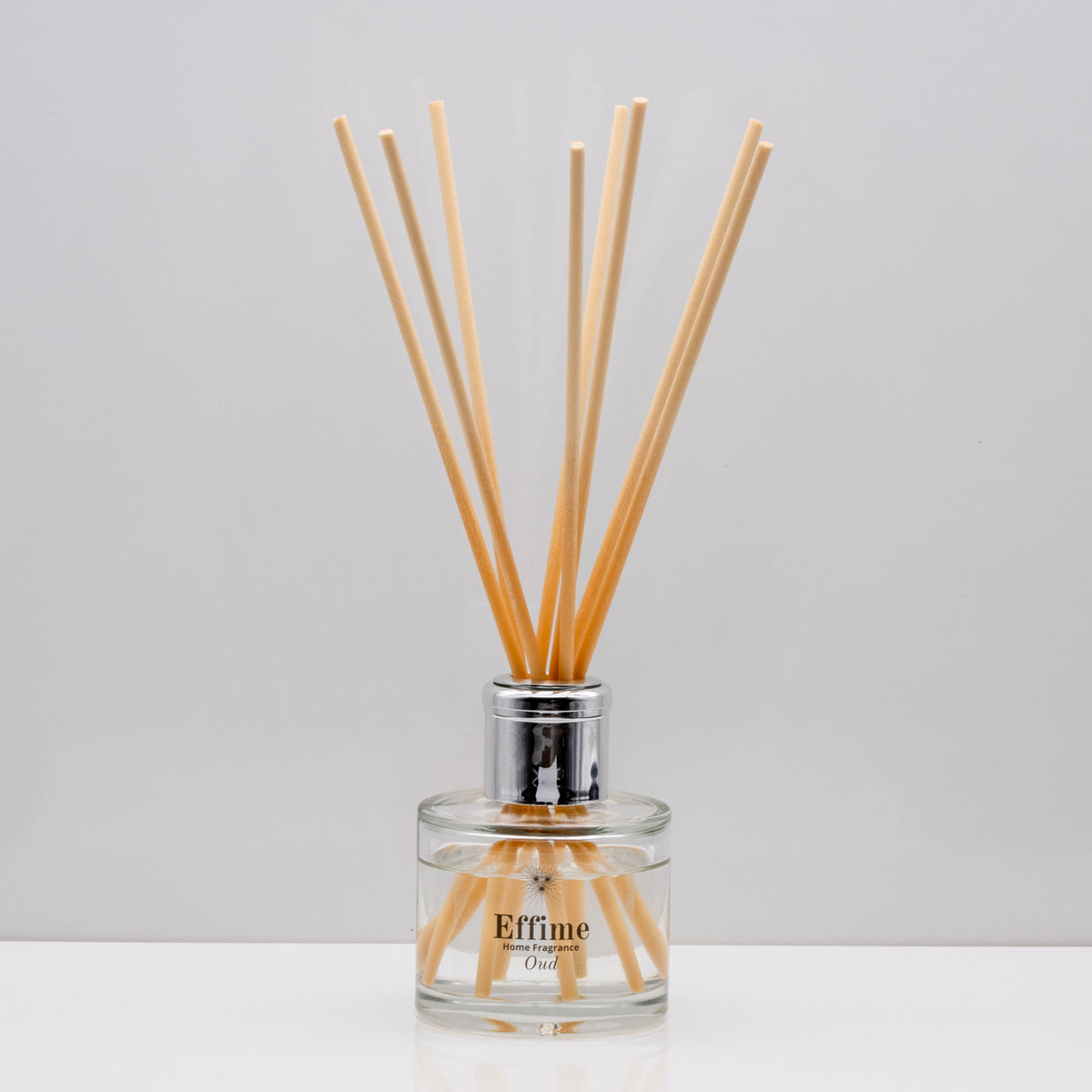 Experience the warm rich, smoky essence of rare Oud wood Luxury long lasting Oud reed diffuser with natural wooden sticks in a 100ml clear glass bottle with silver top
