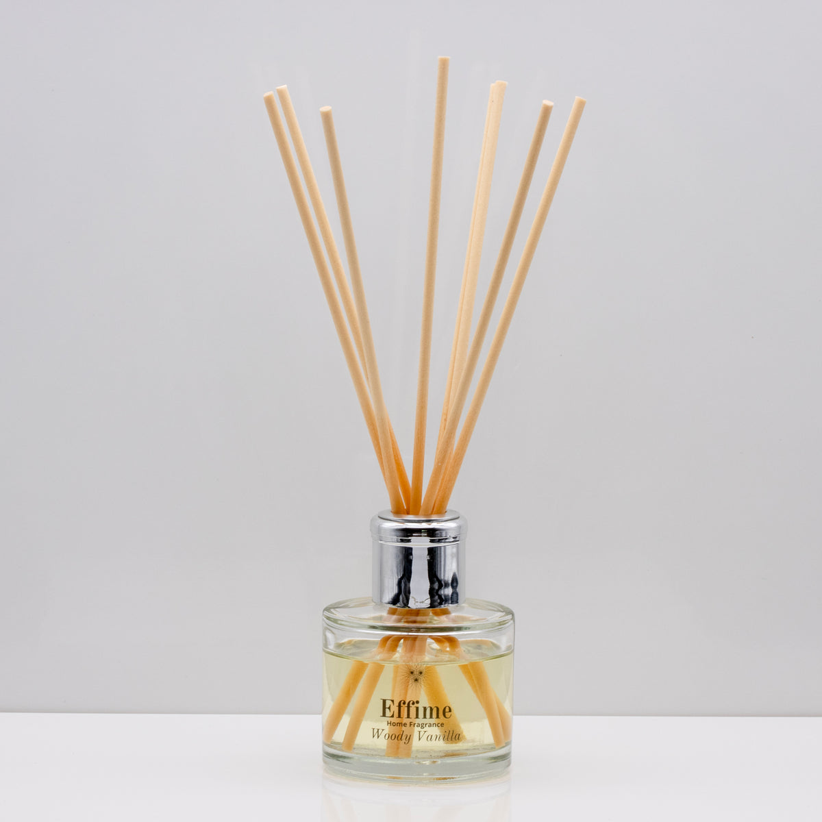Wrap yourself in the comforting warmth of burnt wood and  vanilla Luxury long lasting Woody Vanilla reed diffuser with natural wooden sticks in a 100ml clear glass bottle with silver top