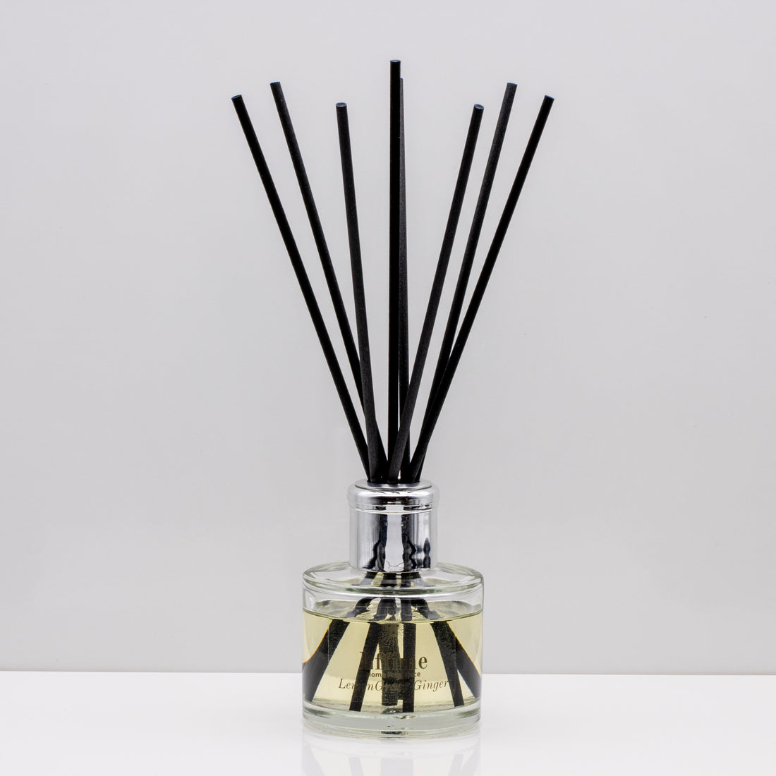 Citrus notes and warm freshly sliced ginger Luxury long lasting Lemongrass Ginger reed diffuser with natural black sticks in a 100ml clear glass bottle with silver top
