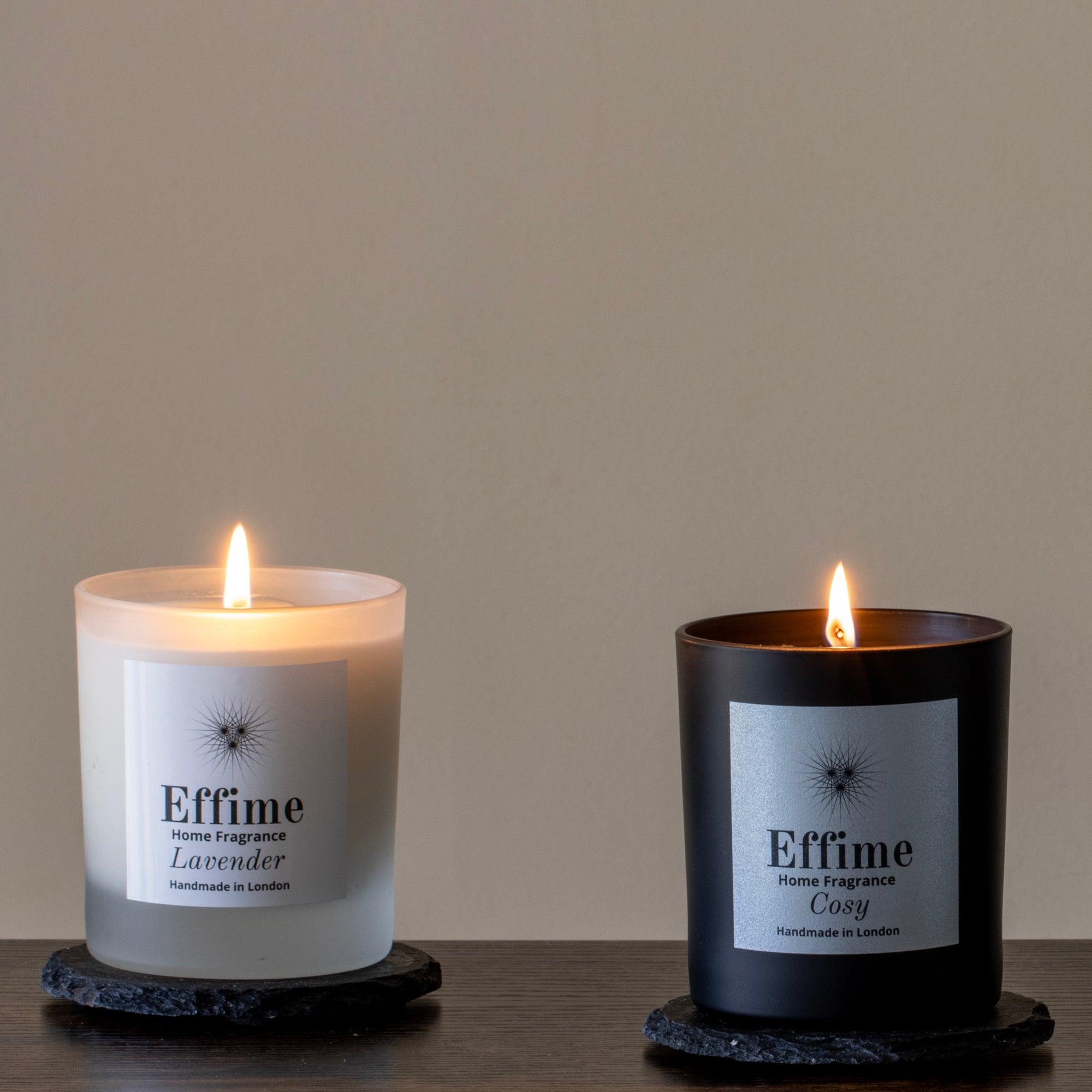 Two Effime candles, one lavender and one cozy, on a wooden surface with a neutral background.