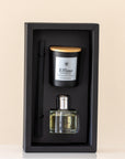 Set of perfume bottle, candle, and pen in a black box on a beige background