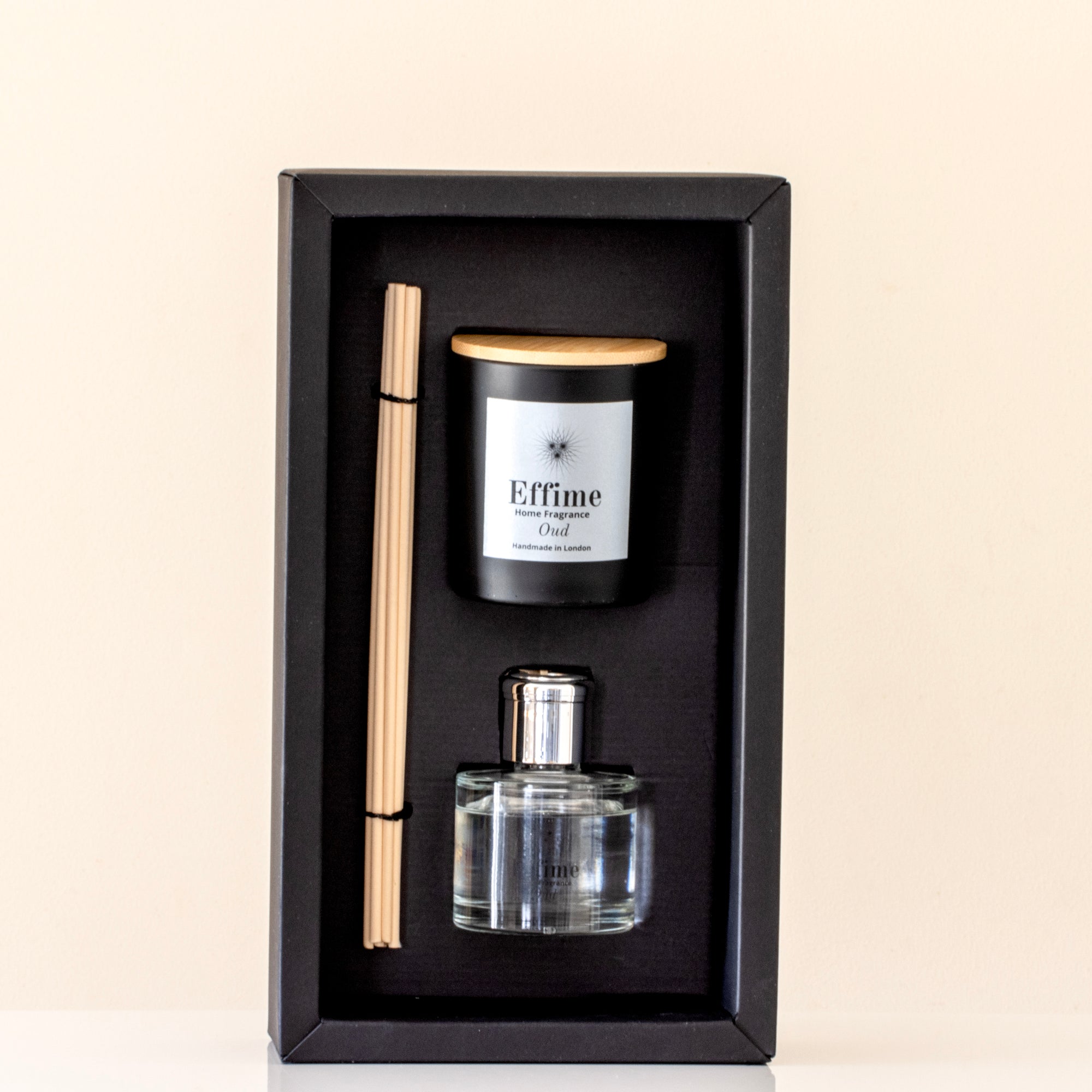 Aromatherapy set with diffuser, candle, and reed sticks in a black box on a beige background.