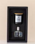 Candle and diffuser set in a black box on a beige background