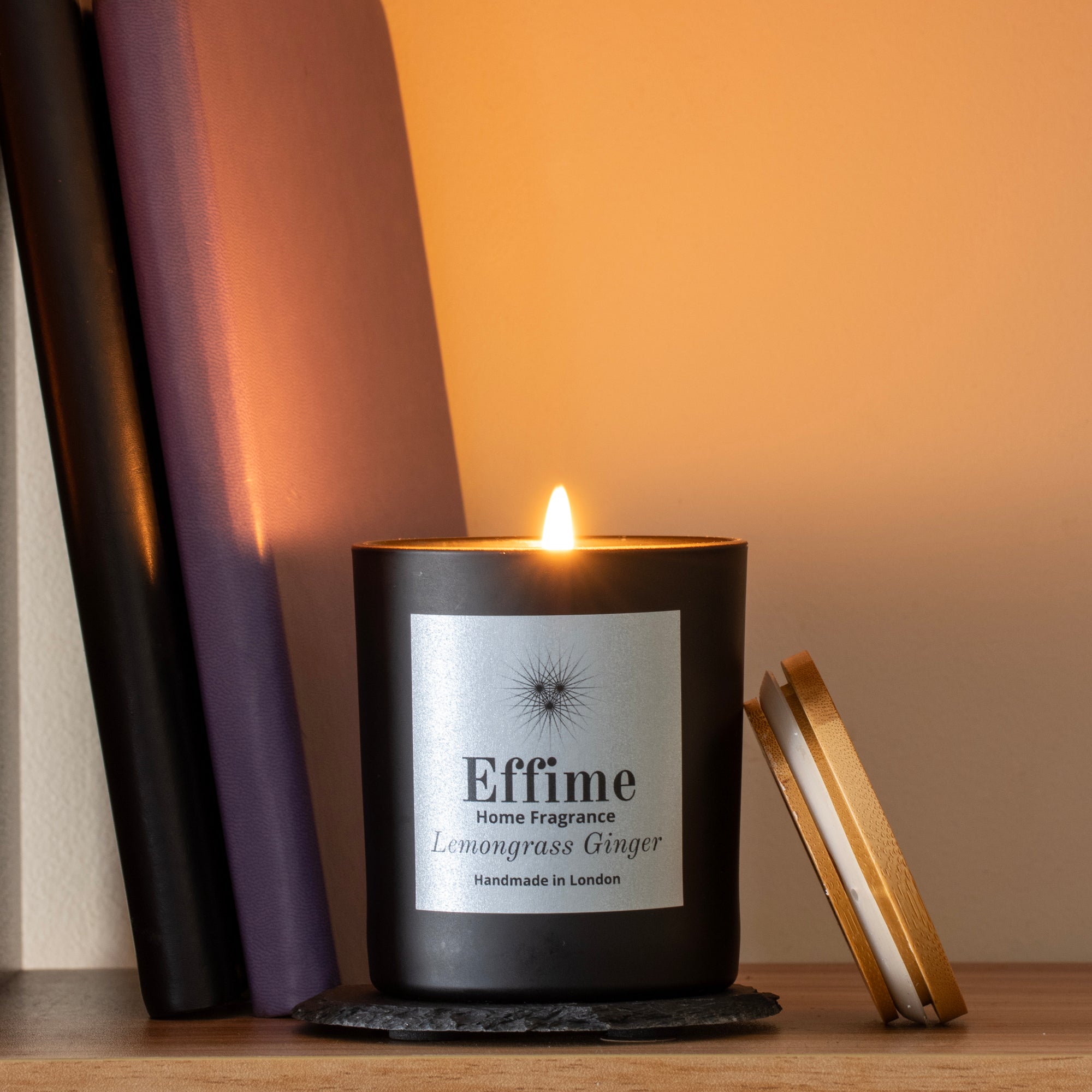 Candle with 'Effime' branding on a wooden surface with a soft background