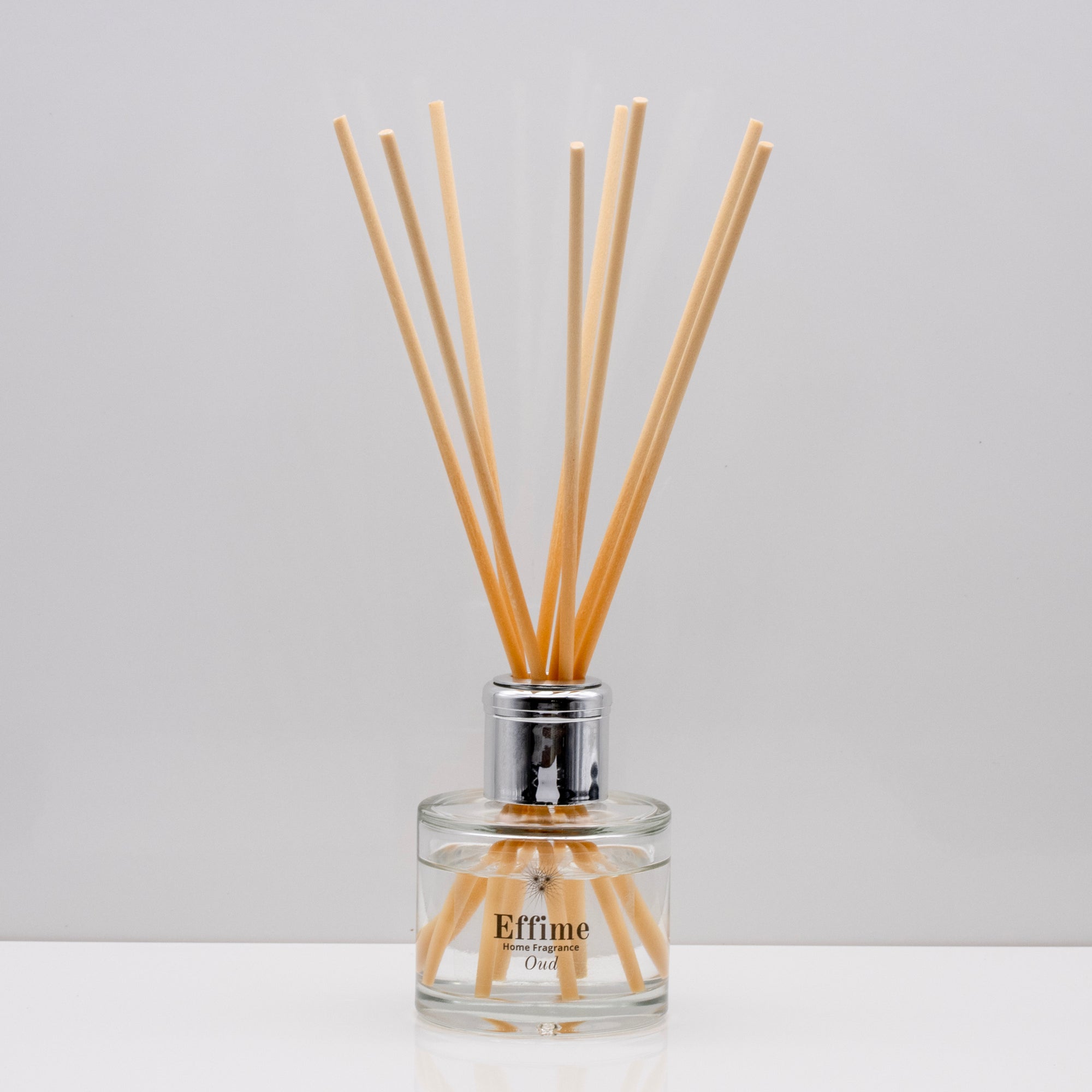 Experience the warm rich, smoky essence of rare Oud wood Luxury long lasting Oud reed diffuser with natural wooden sticks in a 100ml clear glass bottle with silver top