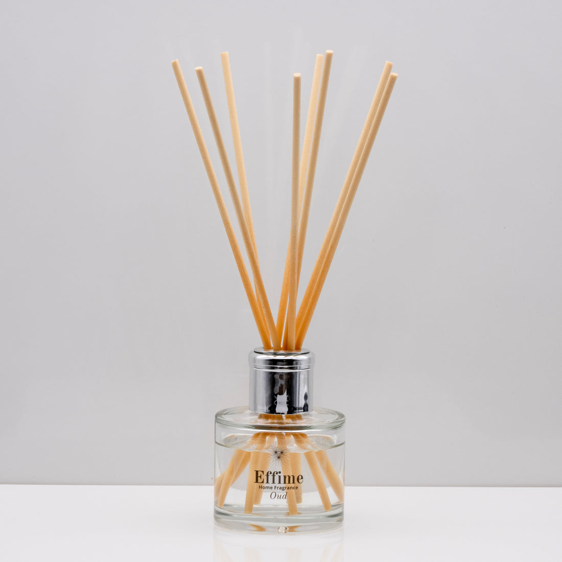 Experience the warm rich, smoky essence of rare Oud wood Luxury long lasting Oud reed diffuser with natural wooden sticks in a 100ml clear glass bottle with silver top