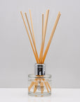 Experience the warm rich, smoky essence of rare Oud wood Luxury long lasting Oud reed diffuser with natural wooden sticks in a 100ml clear glass bottle with silver top
