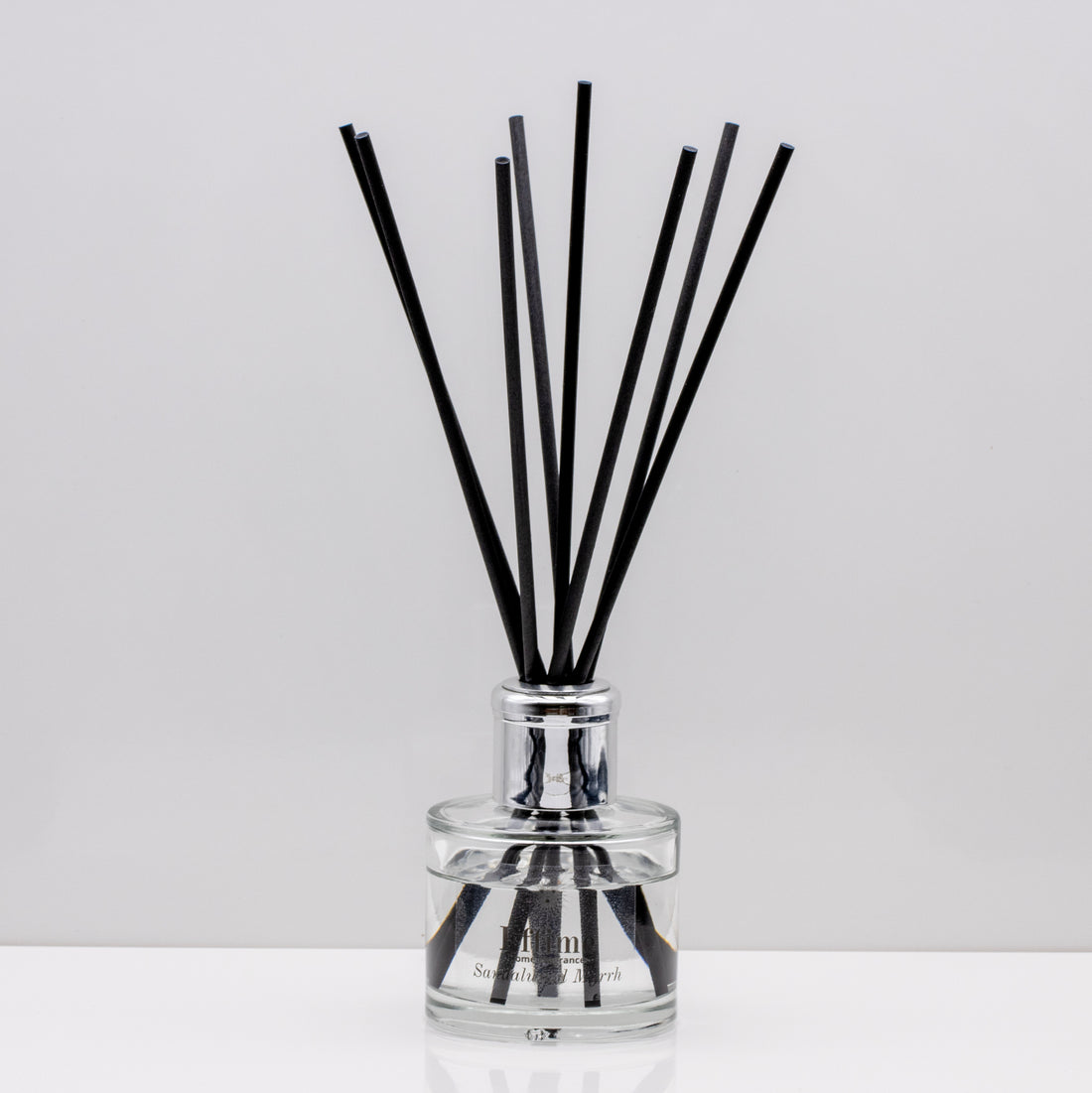 Warm, woody essence of sandalwood with the deep, resinous notes of myrrh Luxury long lasting Sandalwood Myrrh reed diffuser with natural black sticks in a 100ml clear glass bottle with silver top