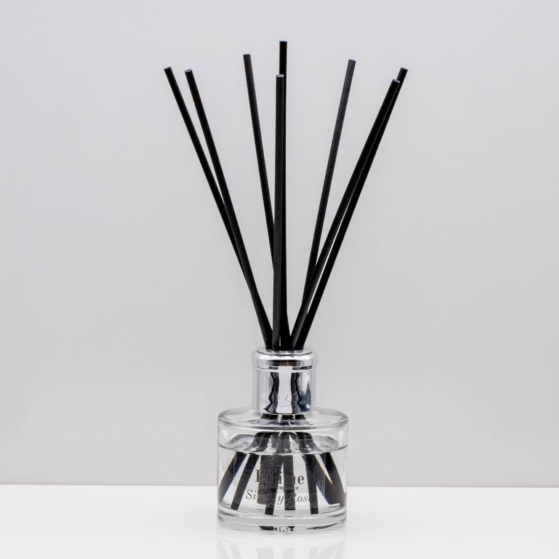 Take a stroll through an English garden, with inviting rose Luxury long lasting Simply Rose reed diffuser with natural black sticks in a 100ml clear glass bottle with silver top.