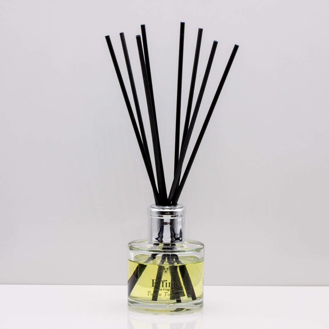 Perfect for slow evenings and quiet moments of reflection Luxury long lasting Tonka Tobacco reed diffuser with natural black sticks in a 100ml clear glass bottle with silver top.
