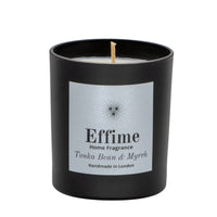 "Scented candle: Black glass jar with silver label reading 'Effime Home Fragrance Tonka Bean & Myrrh'. 
Luxury fruity and Woody home fragrance"